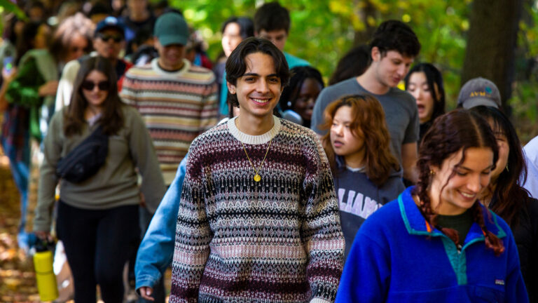 Student walking in the woods on Mountain Day