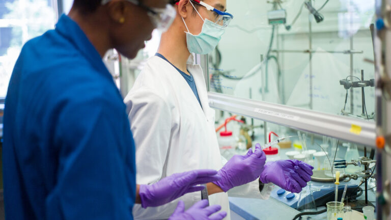 A student works with a professor in a chemistry lab using cutting edge tools