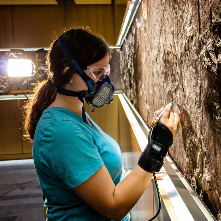 A student uses special equipment to examine a large slab of stone