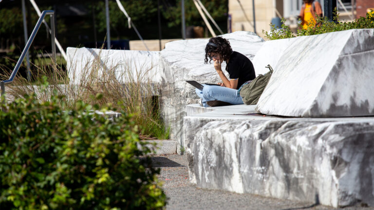 Student studying while sitting on marble slabs