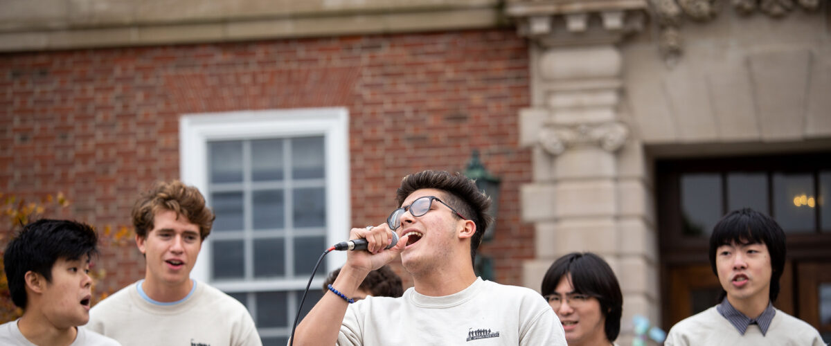 A group of students singing while wearing matching sweaters