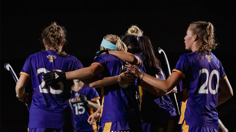 Student field hockey athletes in a huddle