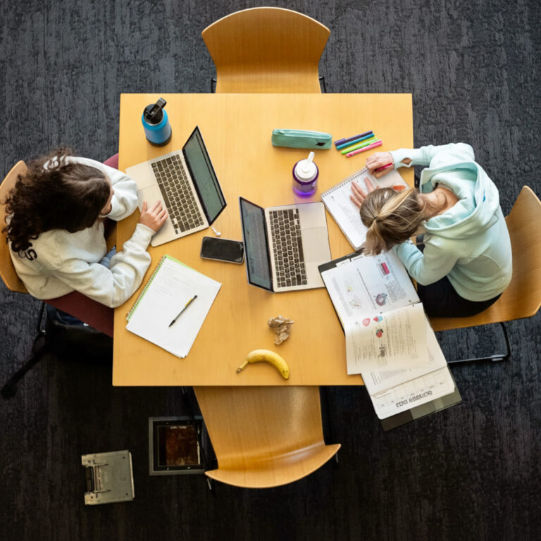 A top-down shot of two students studying at a table