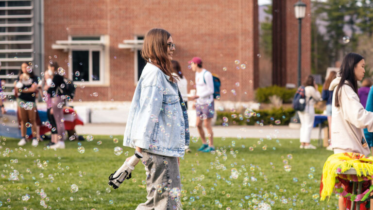 students blowing bubbles on the quad