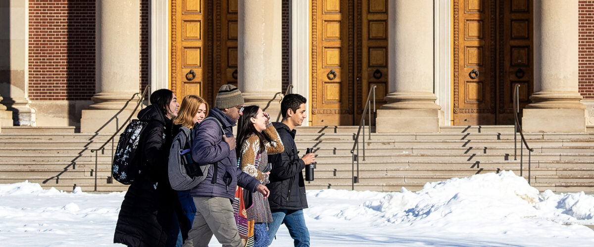 Students walking across campus on a path through the snow