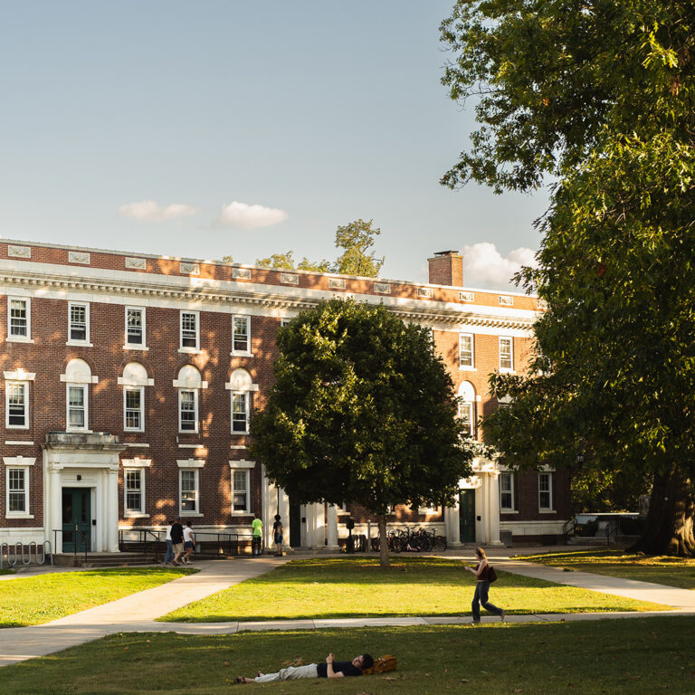 Student laying down in the grass of the Berkshire Quad