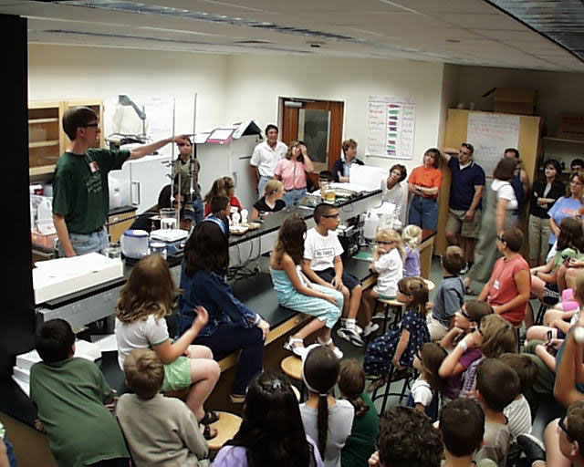 A large group of students having a discussion in a packed classroom