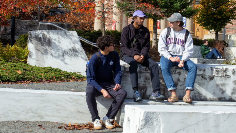 Students having a conversation while sitting on the marble slabs