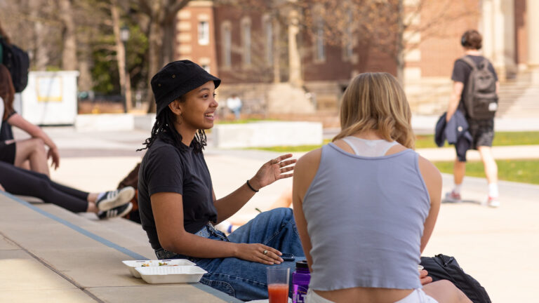 Students having a conversation on the steps of the Paresky Center