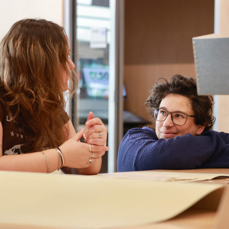 Two class members in conversation in a classroom