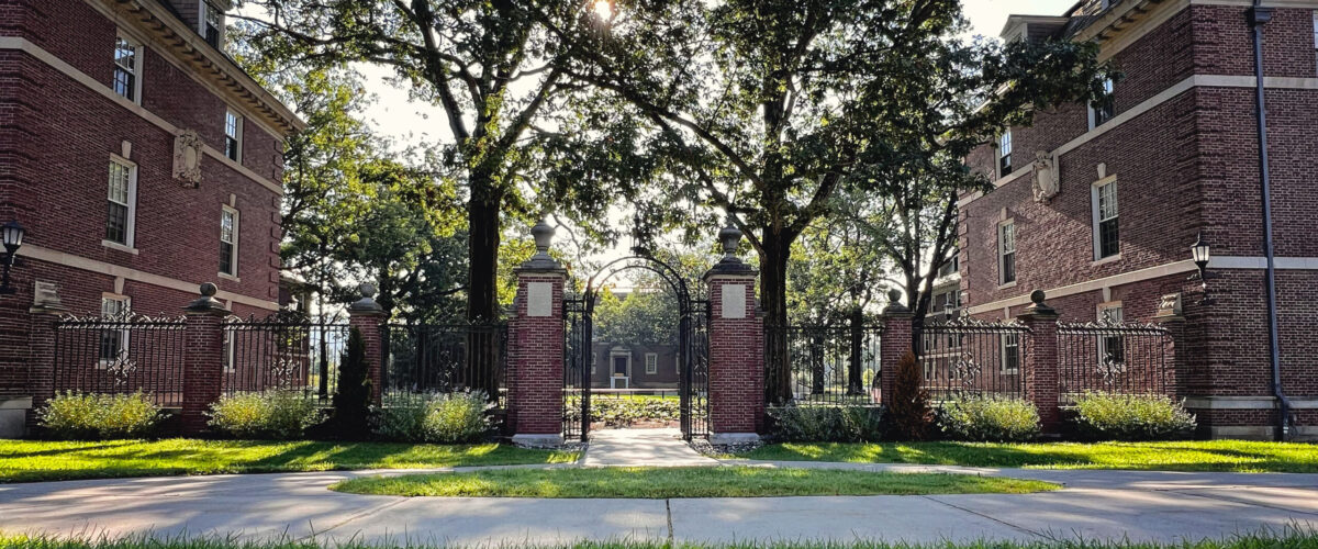 The two brick buildings on Frosh Quad framing an iron gate