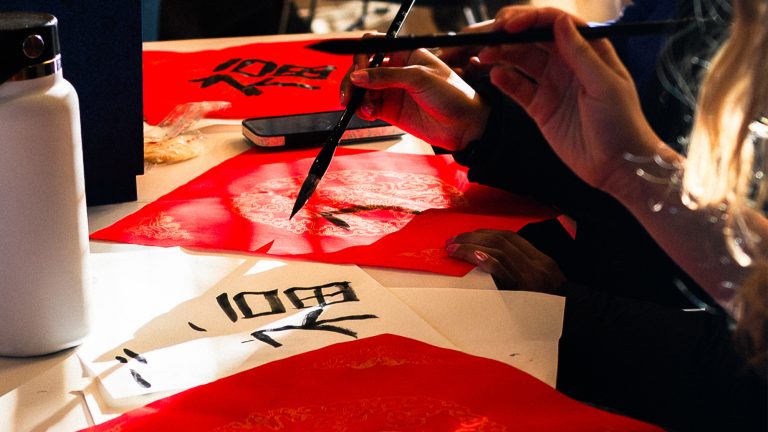 Students writing Chinese calligraphy during a Winter Study session