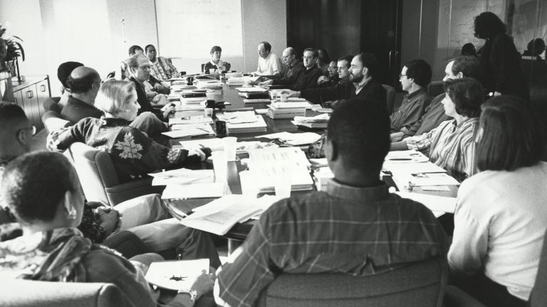 Archival photo of Society of Alumni chairs sitting around a table