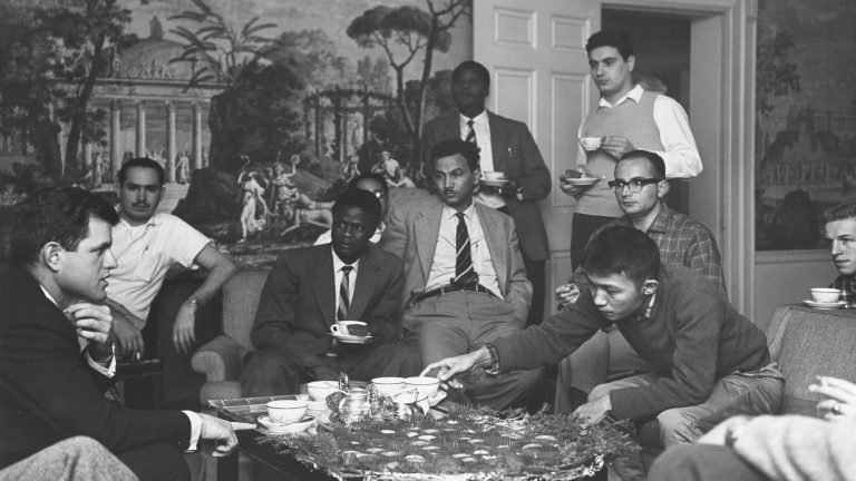 Archival photo of CDE students having tea around a table
