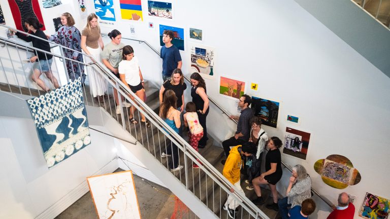 Attendees of the Big Art Show looking at art on stairs