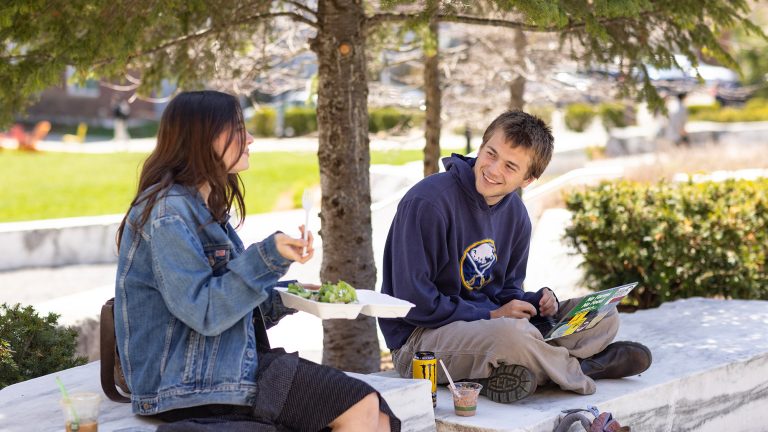 students chatting while sitting outdoors