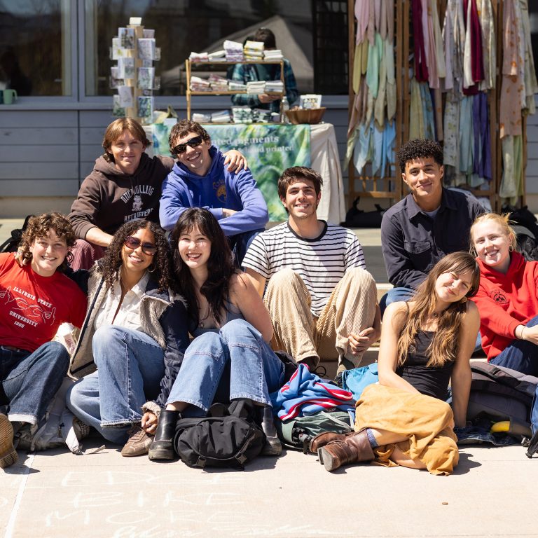 A group of students sitting outside on a sunny day