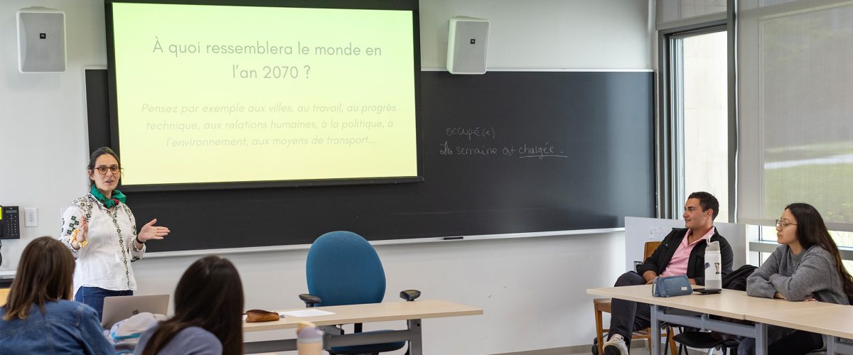 A professor in a classroom leading students in learning French