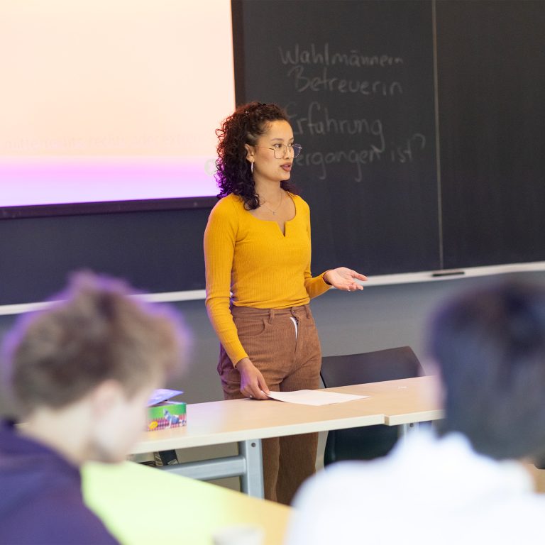 A teaching associate leading students in a classroom