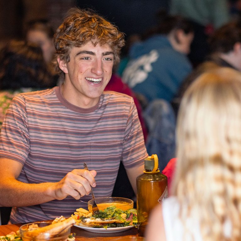 Students eating lunch at a long table