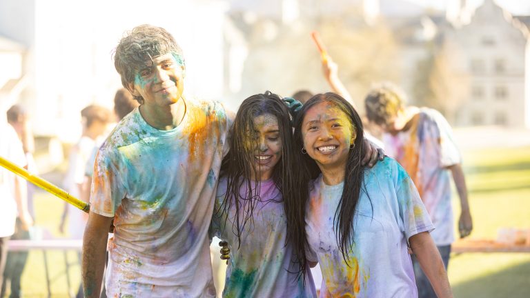 students covered in colored powder at a Holi celebration