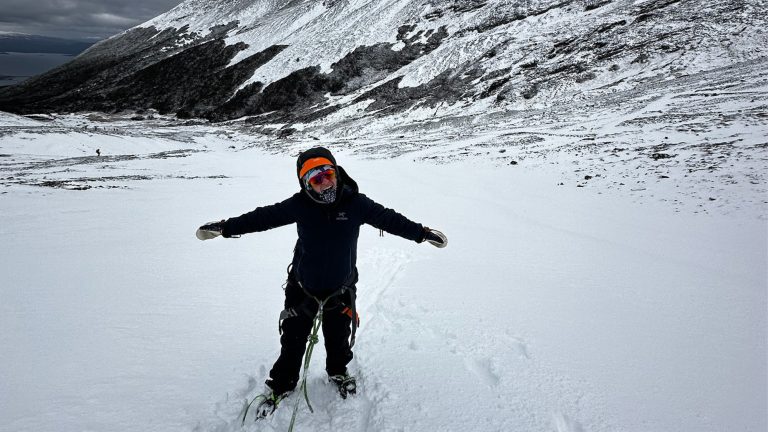 Student tethered and snowshoeing on a snowy mountain