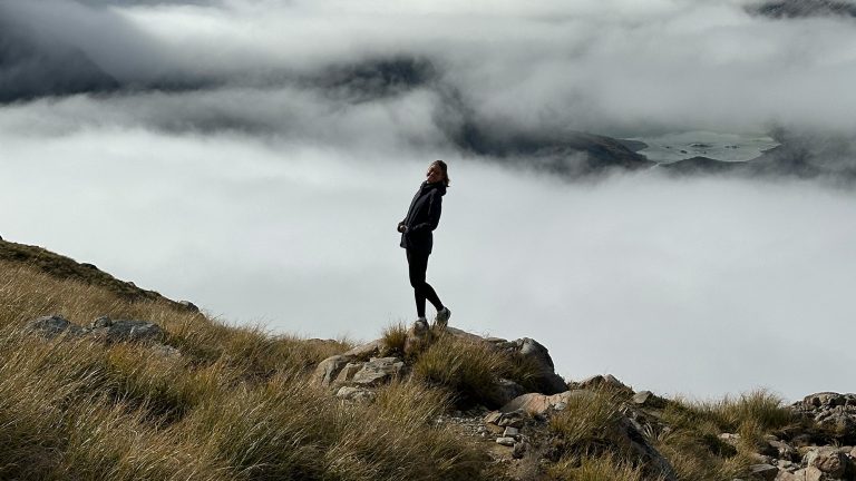 Student posing for a photo in front of mountain fog
