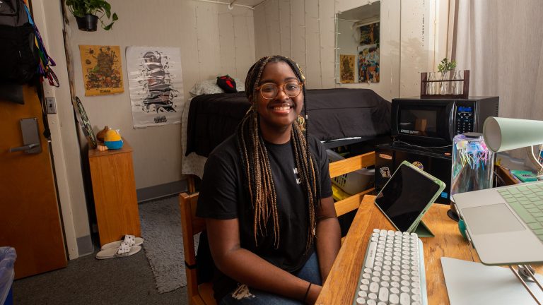 A student sitting in her dorm room
