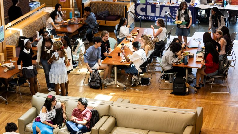 Students sitting at lunch tables and lounging on couches in Baxter Hall