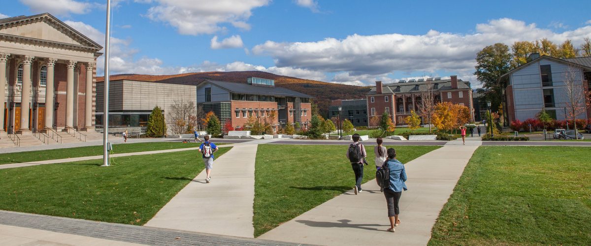 students walk across the quad against the backdrop of the mountains