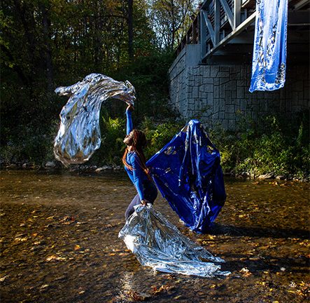 Student dancers performing a dance in a riverbed.