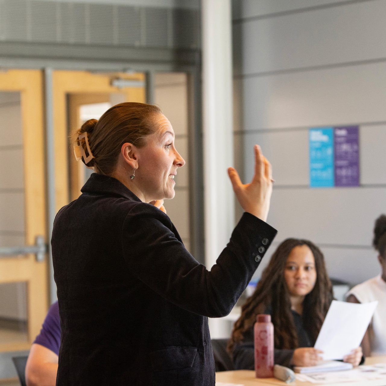 A professor gesticulates while teaching a class
